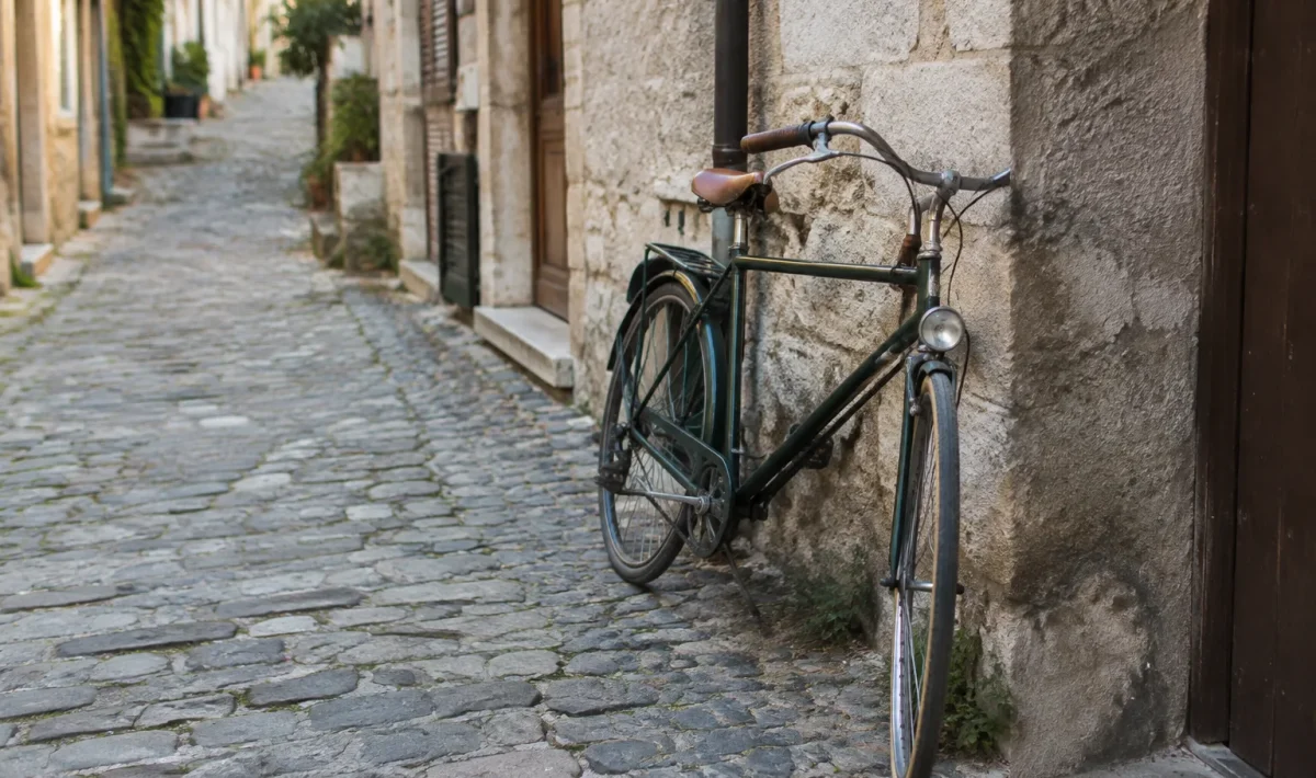 Rue pavee avec velo appuye sur un mur