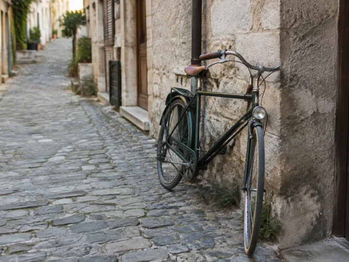 Rue pavee avec velo appuye sur un mur